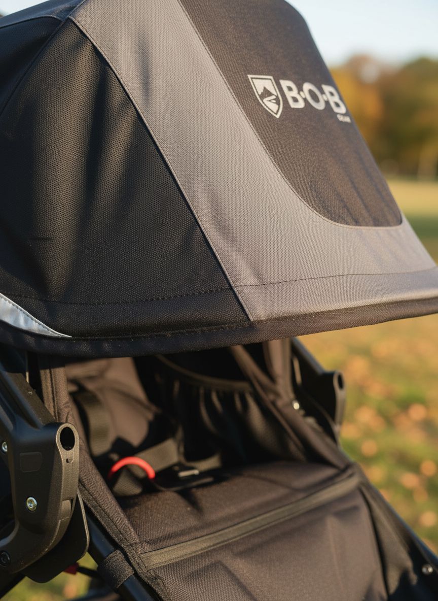 Modern graphite black jogging stroller with large all-terrain wheels and ergonomic parent handlebar for newborn and infant use โ view 4