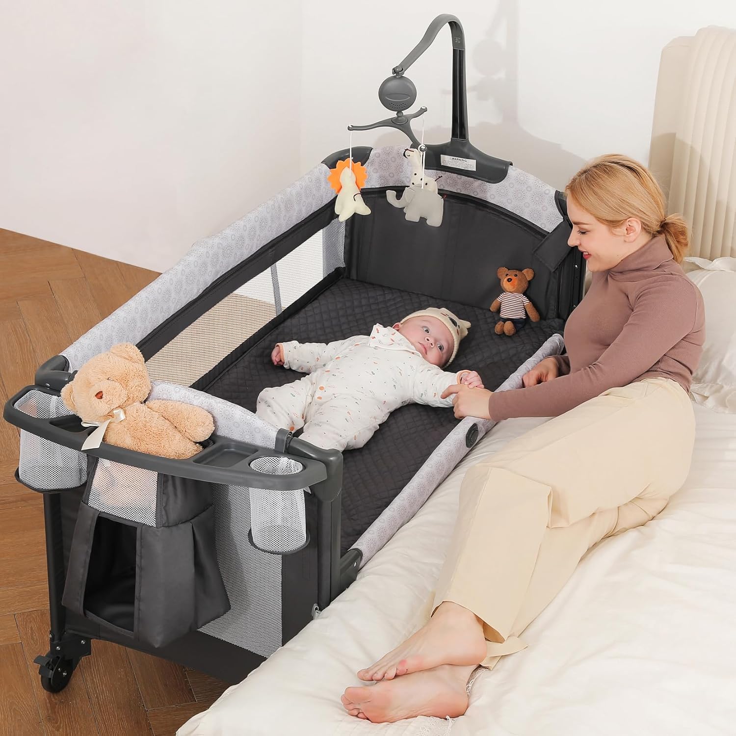 Modern gray 4-in-1 bedside bassinet with integrated diaper changing station, adjustable mattress height, and storage compartment — view 1