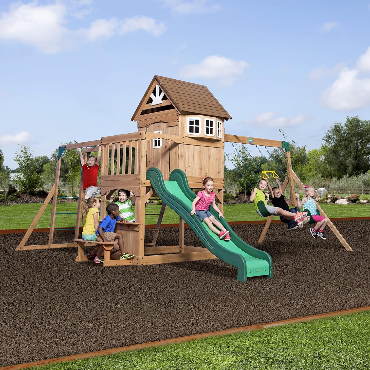 Cedar wood swing set with attached wave slide, clubhouse with working door, monkey bars, and dual belt swings — view 1