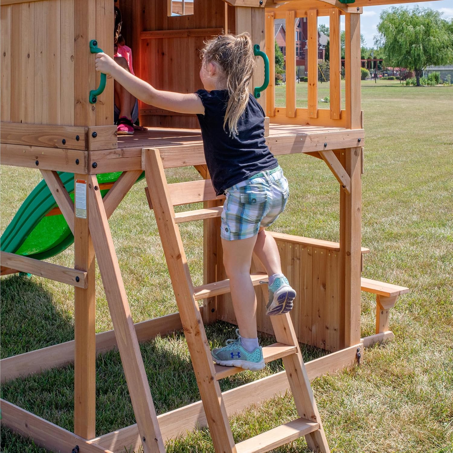 Cedar wood swing set with attached wave slide, clubhouse with working door, monkey bars, and dual belt swings — detail