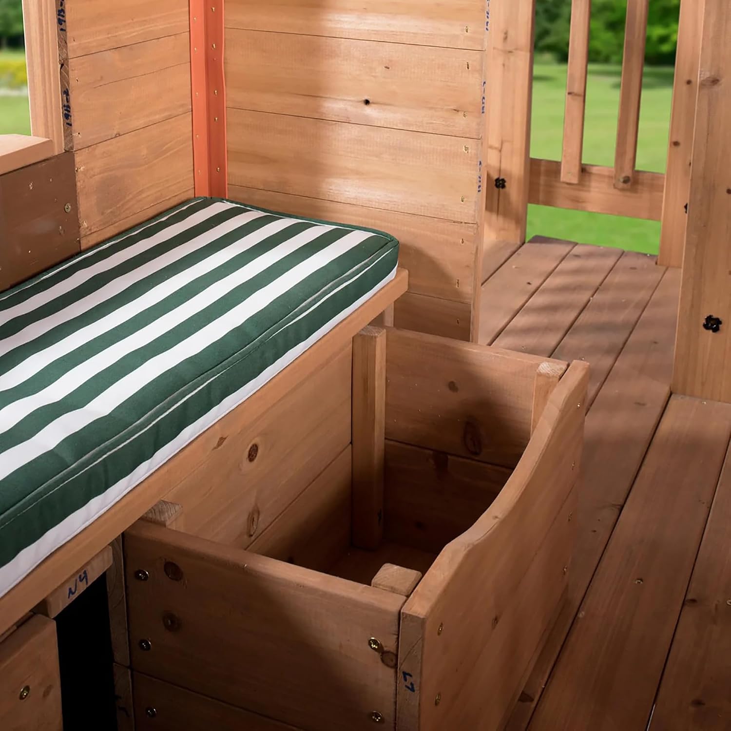 Elevated cedar wooden playhouse with integrated play kitchen, wrap-around deck, and saloon-style doors for outdoor play — detail
