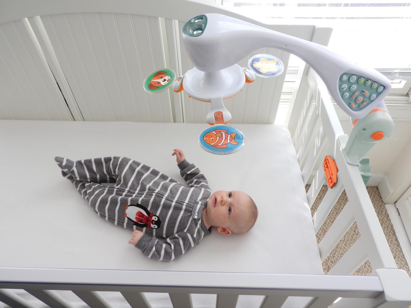 Modern crib mobile with integrated projector and white finish, featuring sound and light options for newborn soothing โ view 2