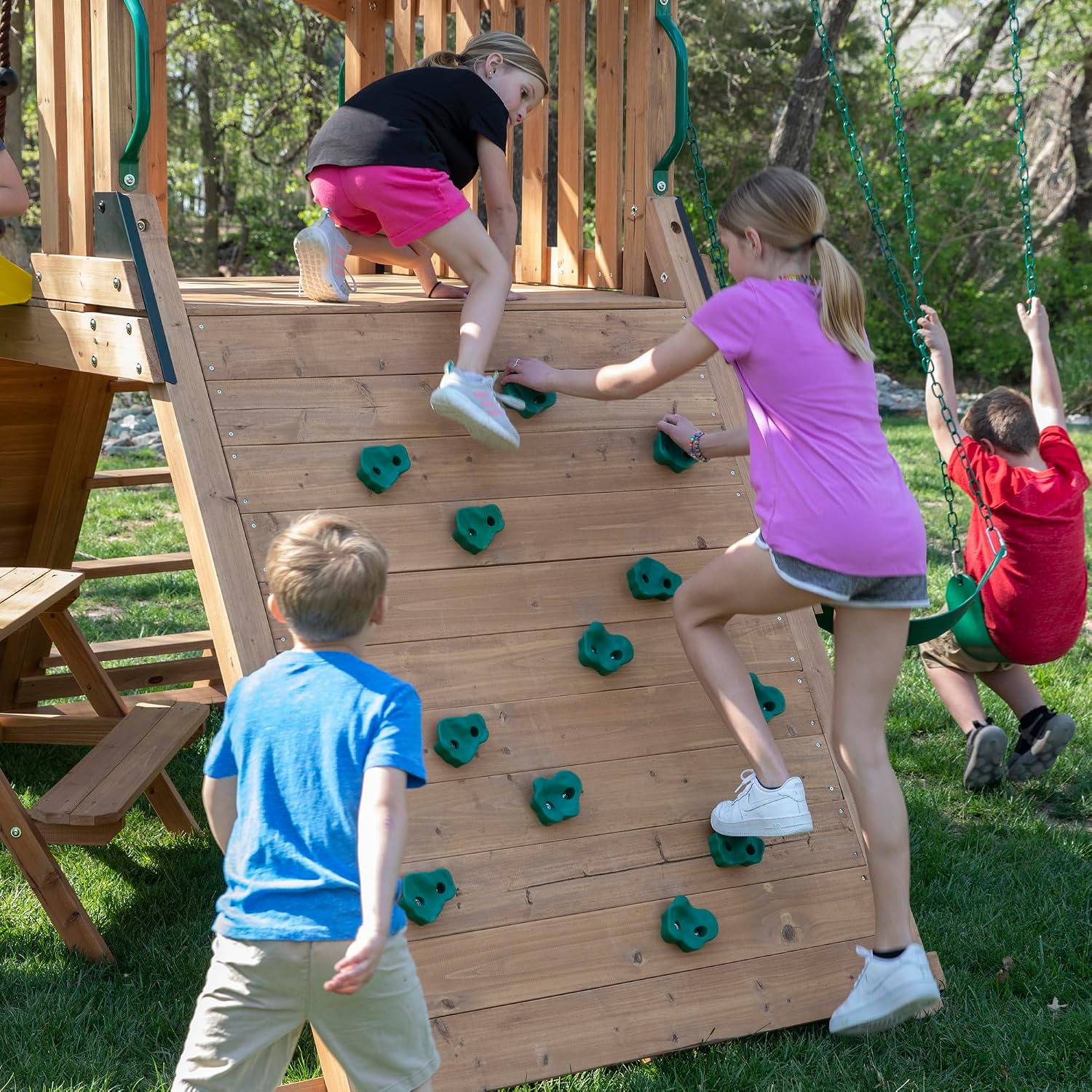 Cedar wood outdoor swing set with integrated wave slide, double rock wall, web swing, and elevated play deck for children ages 3-8 — view 2