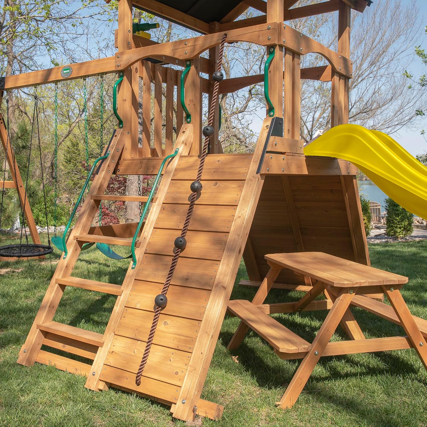 Cedar wood outdoor swing set with integrated wave slide, double rock wall, web swing, and elevated play deck for children ages 3-8 — view 3