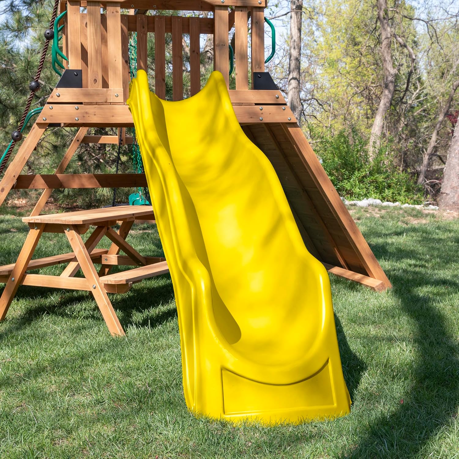 Cedar wood outdoor swing set with integrated wave slide, double rock wall, web swing, and elevated play deck for children ages 3-8 — view 3a