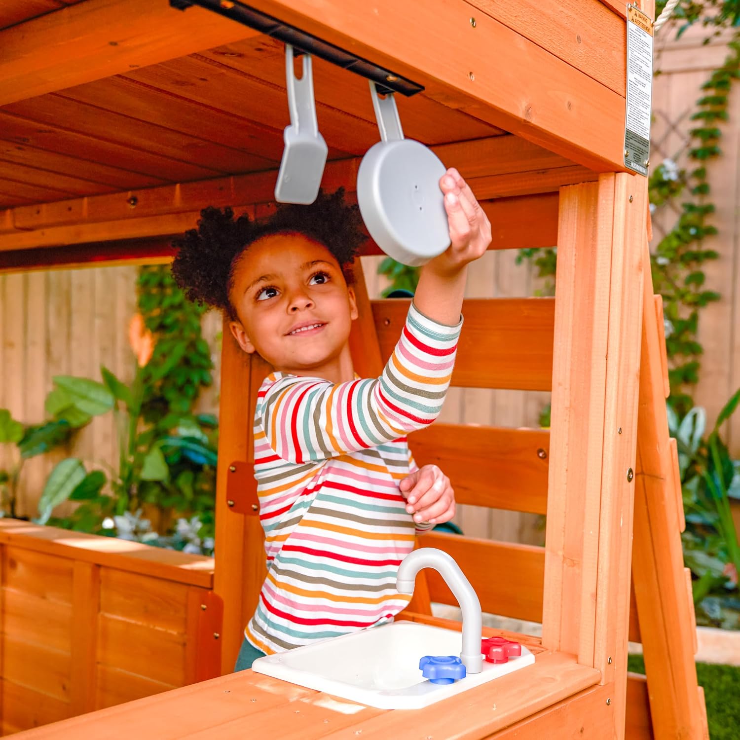 Wooden outdoor swing set with three slides, climbing wall, glider, and integrated play kitchen with cafe window for preschoolers — view 5