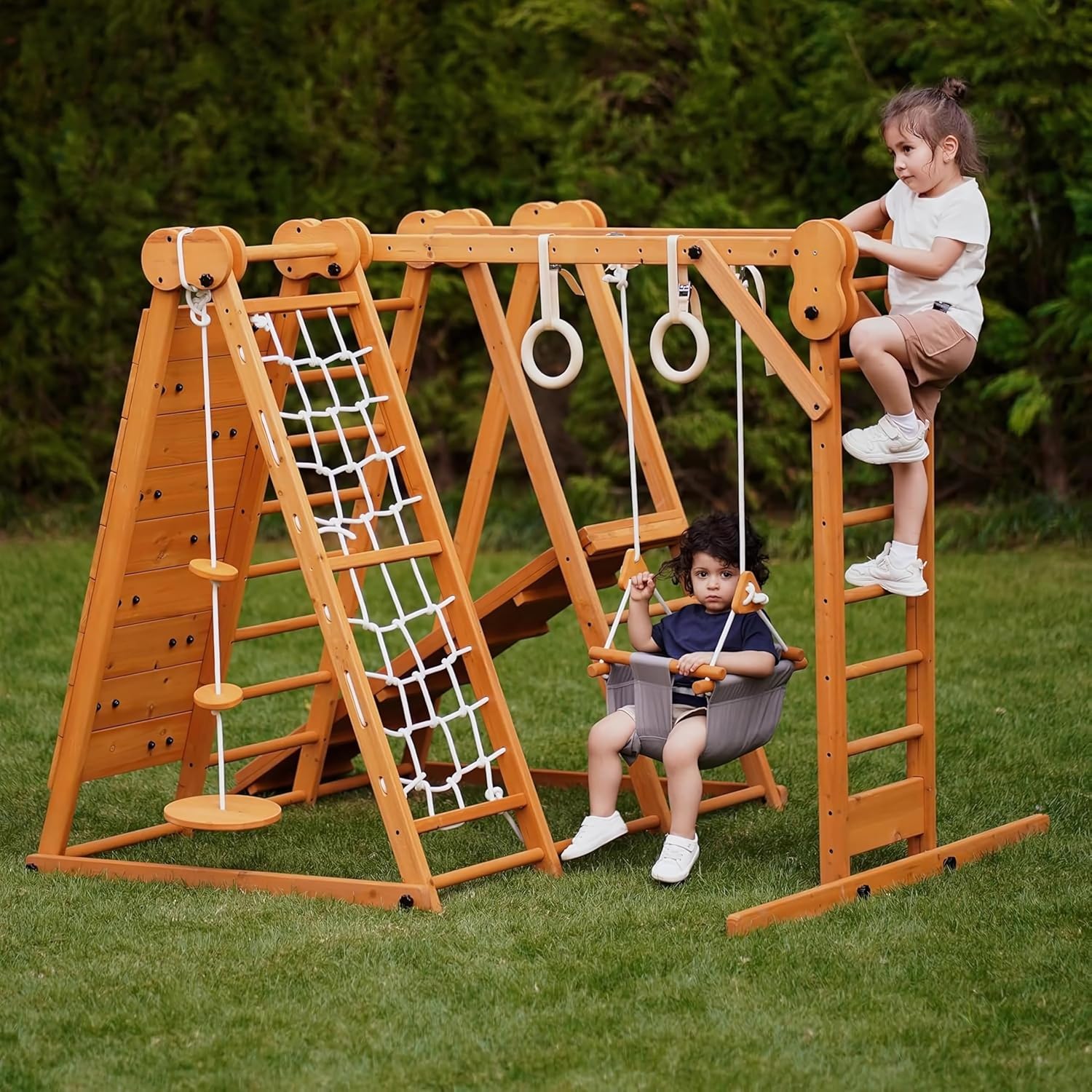 Natural wood 8-in-1 playset with slide, monkey bars, two swings, rock climbing wall, and gym rings for toddlers — back