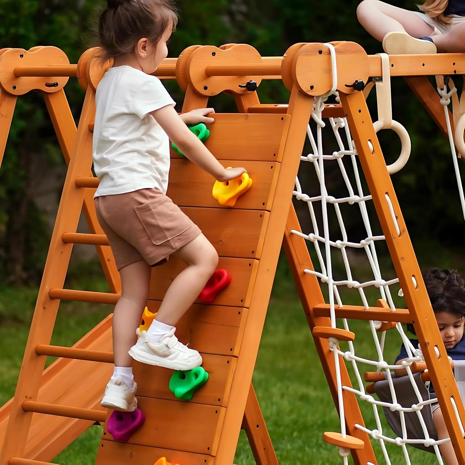 Natural wood 8-in-1 playset with slide, monkey bars, two swings, rock climbing wall, and gym rings for toddlers — detail