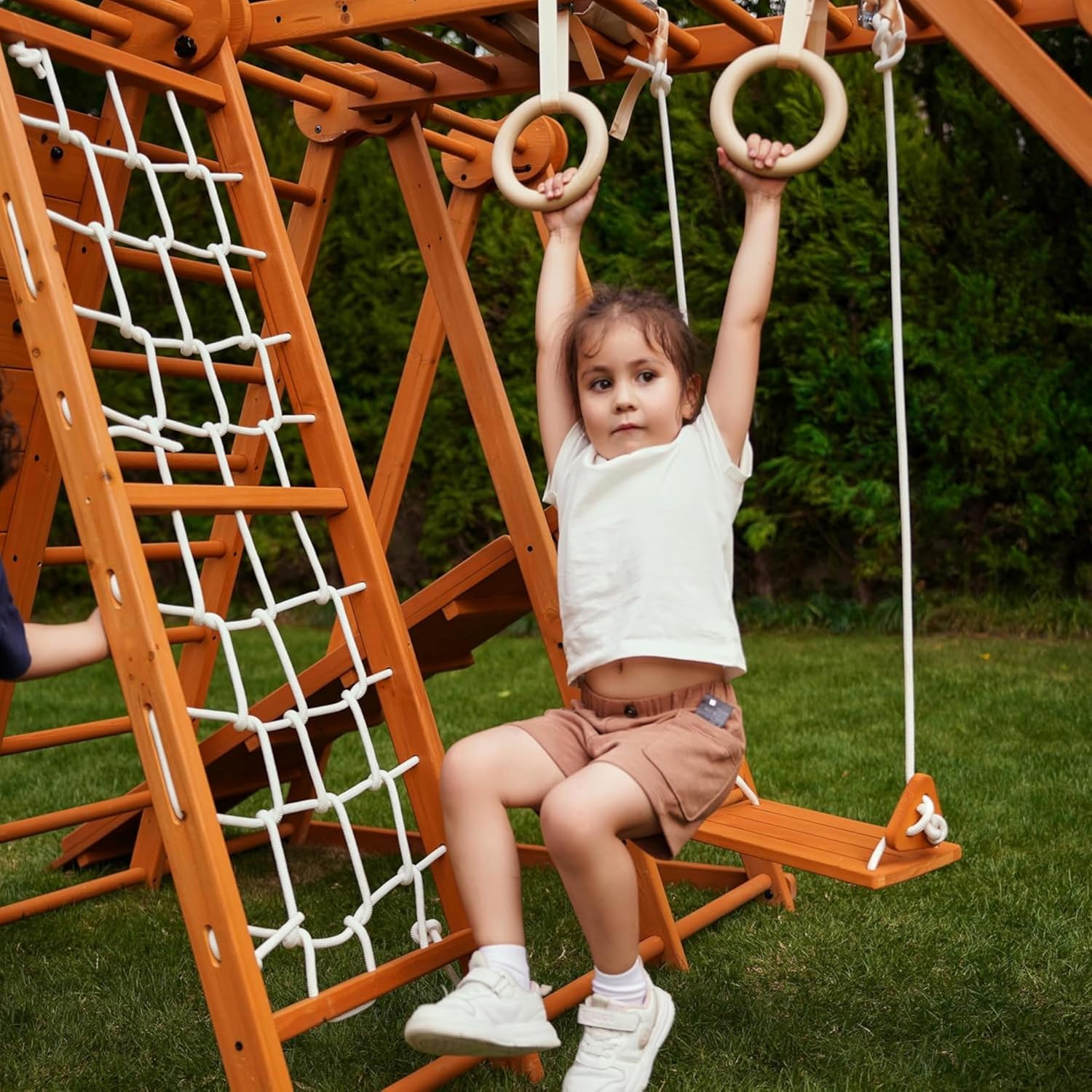 Natural wood 8-in-1 playset with slide, monkey bars, two swings, rock climbing wall, and gym rings for toddlers — view 4